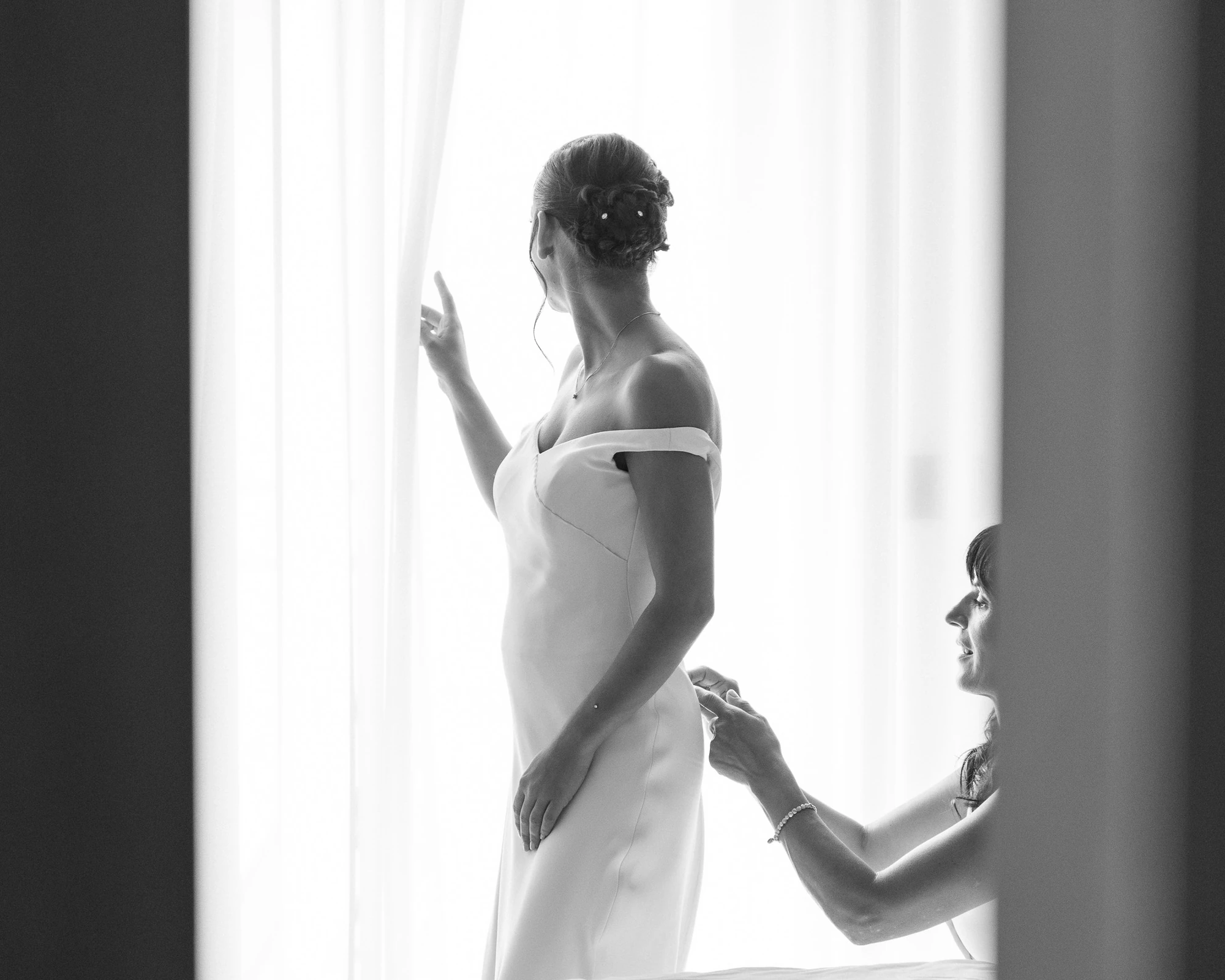 La sposa alla finestra durante i preparativi, in controluce