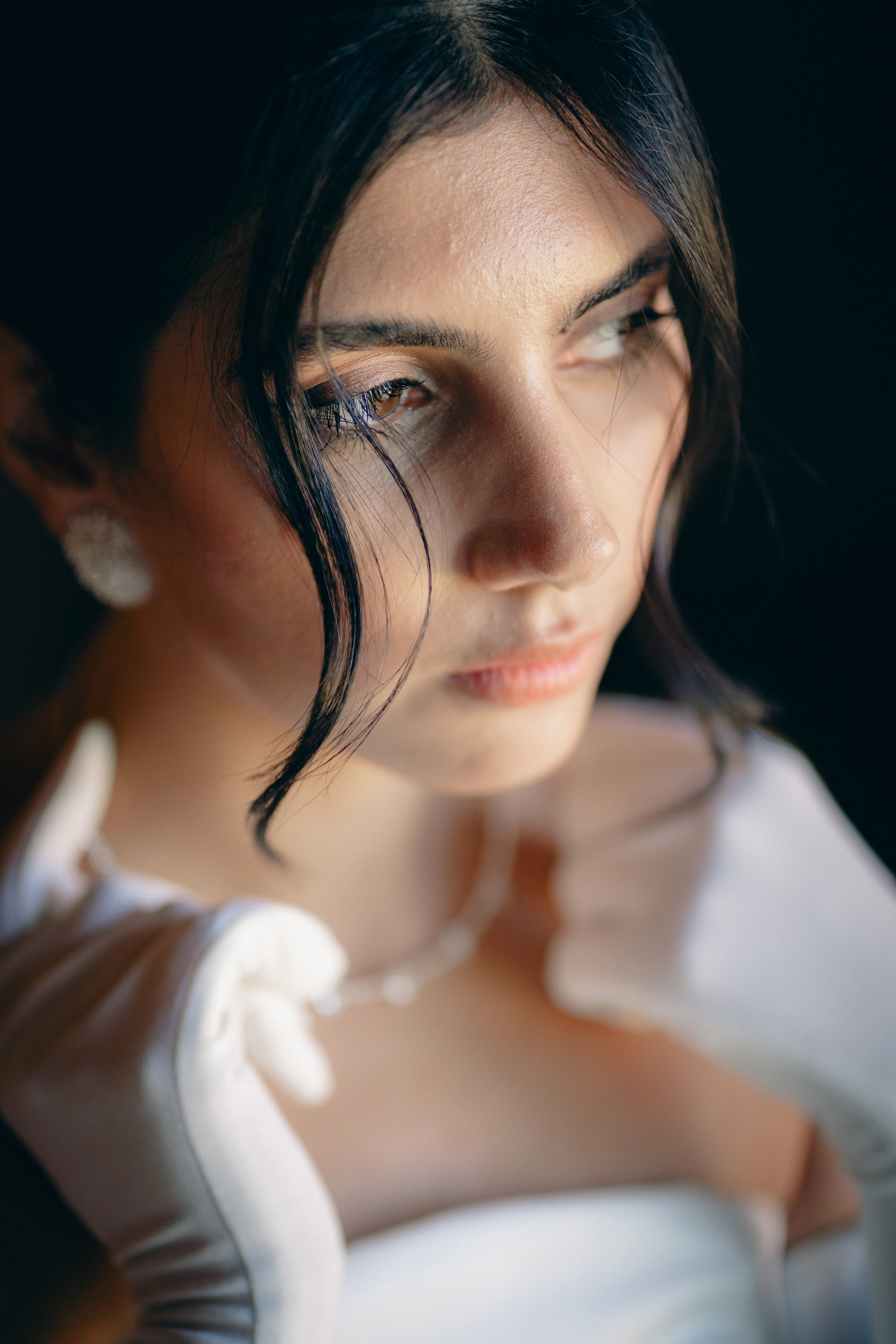 Ritratto della sposa, lo sguardo oltre il velo appoggiato sul viso