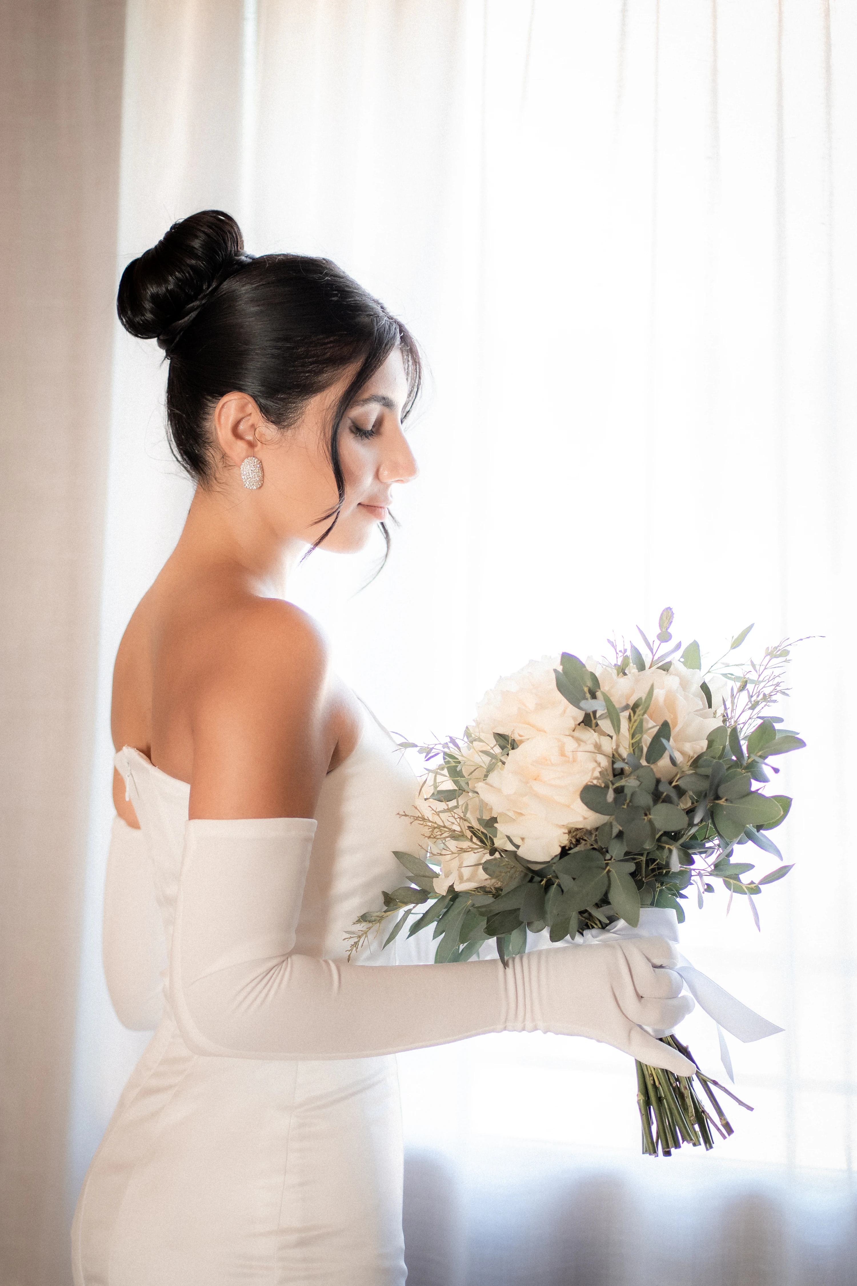 Ritratto della sposa con il bouquet, accanto alla finestra